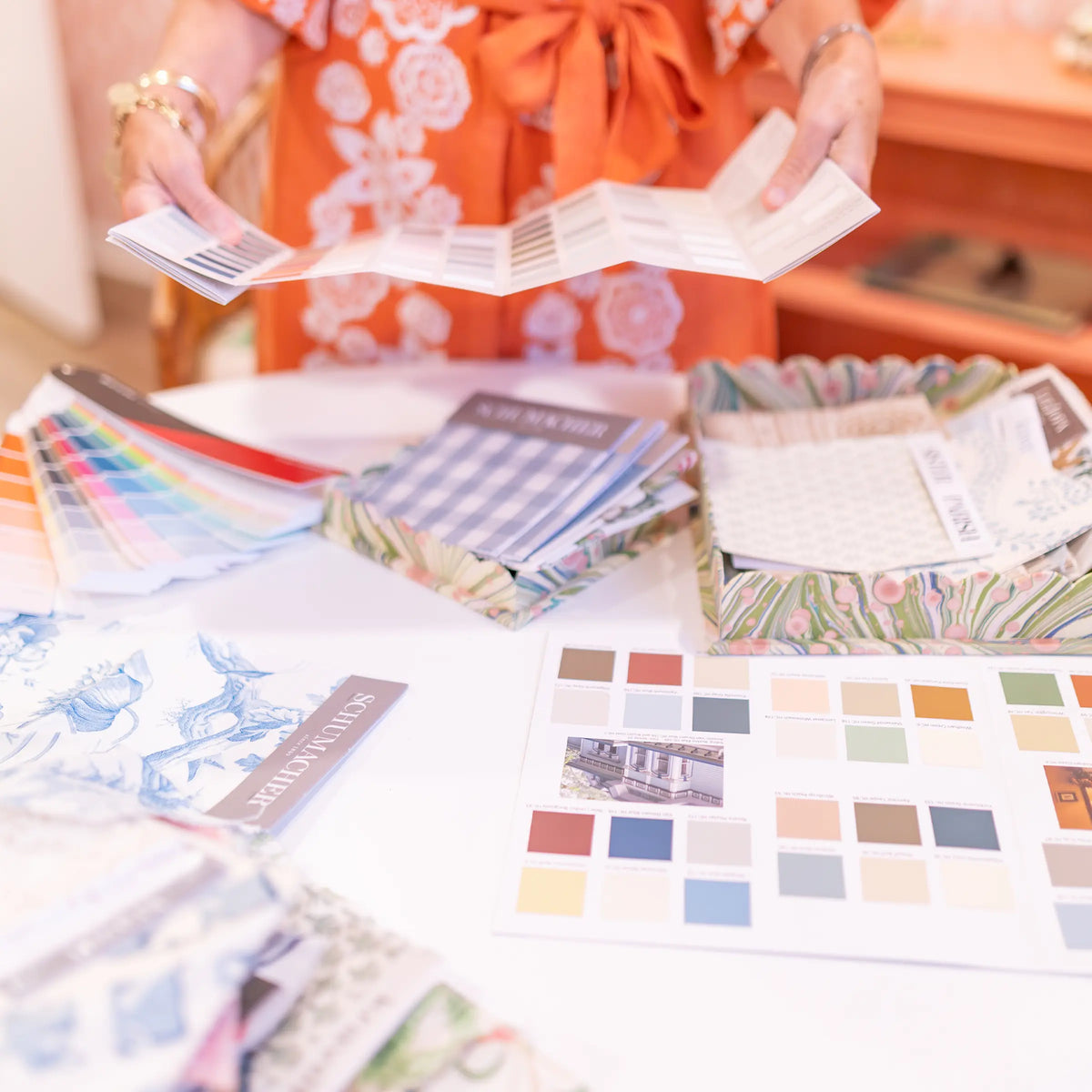 Sibby reviews fabric swatches and colour samples for an interior design project at Riverview Collection.